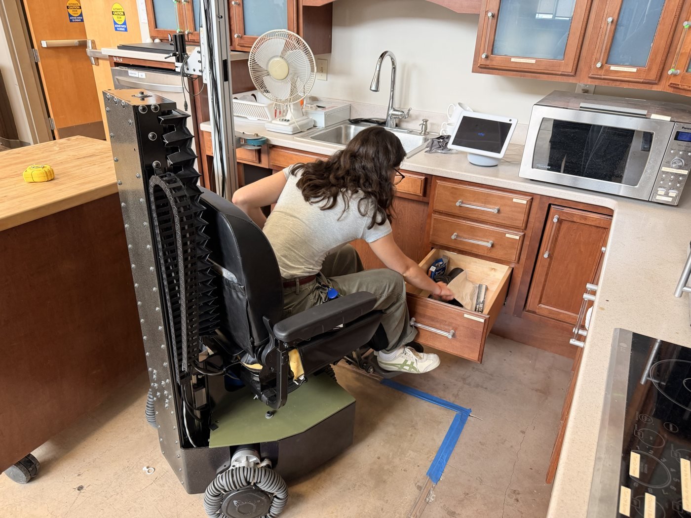Seat lowered, reaching a floor drawer